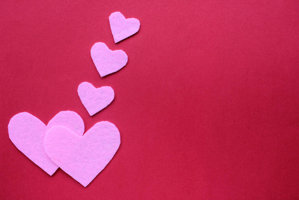 Coeurs faits à la main en feutre sur fond rouge. Composition plate de la Saint-Valentin. Espace de copie - Photo, image