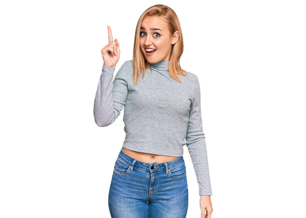 Beautiful caucasian woman wearing casual clothes pointing finger up with successful idea. exited and happy. number one.  - Photo, image