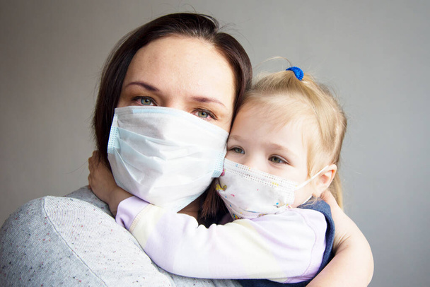 una madre con un niño en máscaras médicas - Foto, imagen