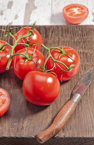A vertical closeup high angle shot of tomatoes on a wooden board - Φωτογραφία, εικόνα