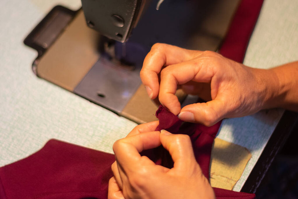 A closeup shot of a person working on a sewing machine - Fotó, kép