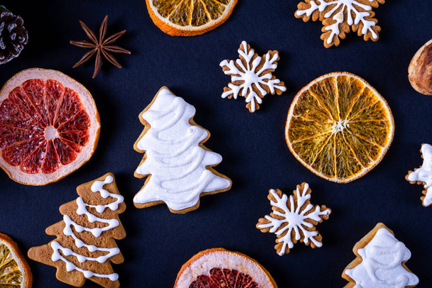 Christmas background: homemade gingerbread cookies on a black background. New year banner. - Foto, afbeelding