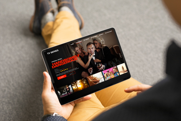 Mężczyzna patrząc seriali telewizyjnych i filmów za pośrednictwem usługi streamingu na swoim tablecie cyfrowym - Zdjęcie, obraz