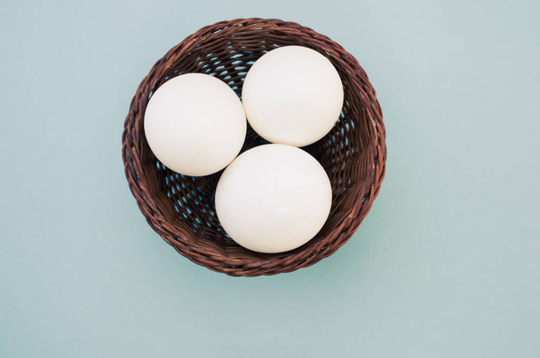 A high angle shot of a basket of eggs on a blue surface - Photo, image