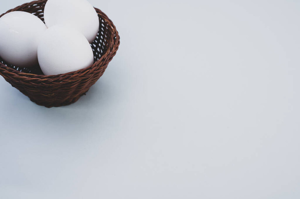 A high angle shot of a basket of eggs on a blue surface - Zdjęcie, obraz