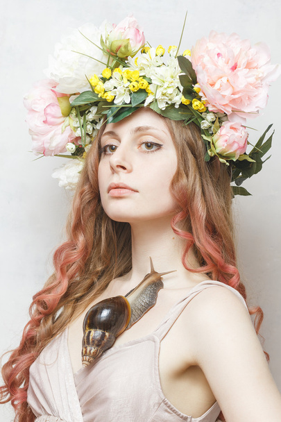 Calma menina bonita com caracol e coroa de flores na cabeça
  - Foto, Imagem