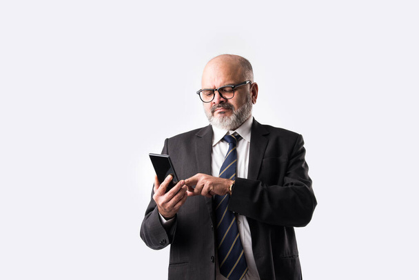Portrait of old Indian asian businessman using smartphone for messaging, calling or showing or presenting against white background - Photo, Image