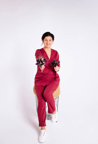 female nutritionist in a bathrobe and with different vegetables on a white background - Foto, afbeelding