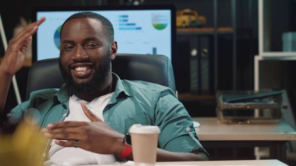 Κοντινό πλάνο χαμογελαστός Αφροαμερικάνος επιχειρηματίας που διασκεδάζει σε hipster γραφείο - Φωτογραφία, εικόνα