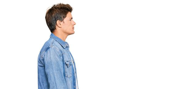 Handsome caucasian man wearing casual denim jacket looking to side, relax profile pose with natural face with confident smile.  - Photo, Image