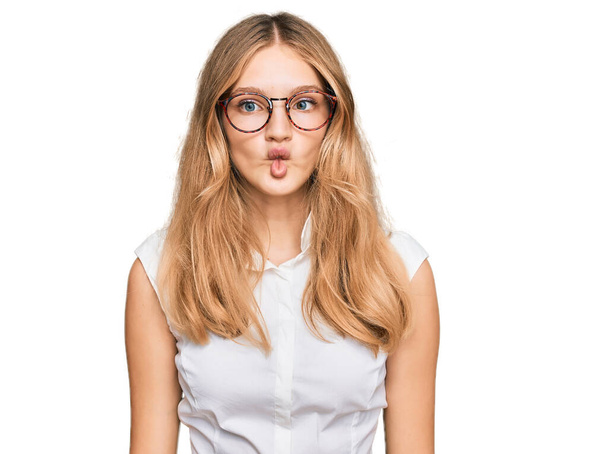 Beautiful young caucasian girl wearing casual clothes and glasses making fish face with lips, crazy and comical gesture. funny expression.  - Foto, Imagem