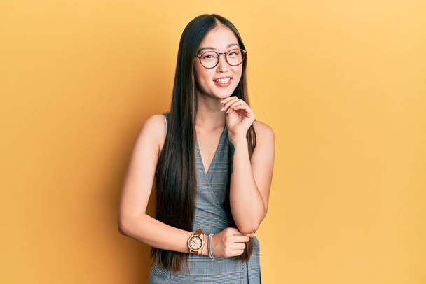 Young chinese woman wearing business dress and glasses smiling looking confident at the camera with crossed arms and hand on chin. thinking positive.  - Photo, Image