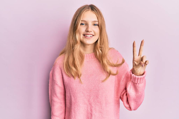 Bella ragazza caucasica che indossa abiti casual mostrando e indicando con le dita numero due mentre sorride fiducioso e felice.  - Foto, immagini