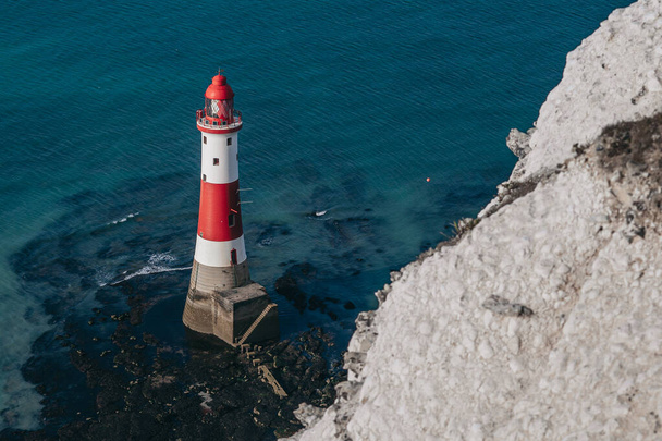 Пейзаж фотографії маяка Beachy Head Lighthouse і крейдяних скель на яскравому сході сонця з низьким припливом в Англії, недалеко від Істборна. - Фото, зображення