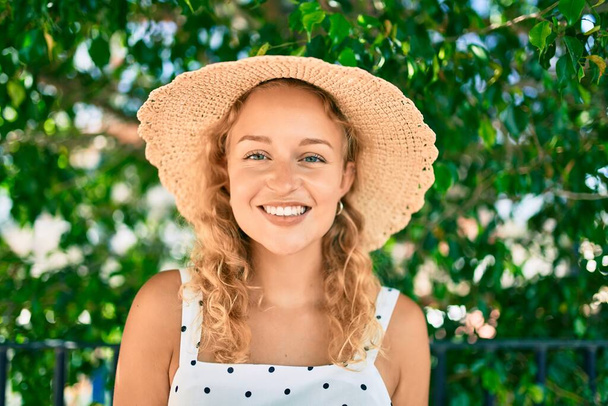 Młoda piękna biała kobieta z blond włosami uśmiechnięta szczęśliwa na świeżym powietrzu w letni dzień - Zdjęcie, obraz