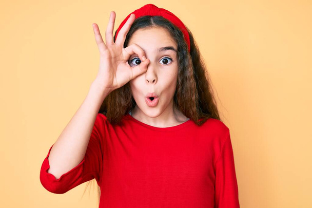 Cute Latynoska dziewczyna nosi ubrania casual i diadem robi ok gest wstrząśnięty zaskoczony twarzy, oko patrząc przez palce. niewierząca ekspresja.  - Zdjęcie, obraz