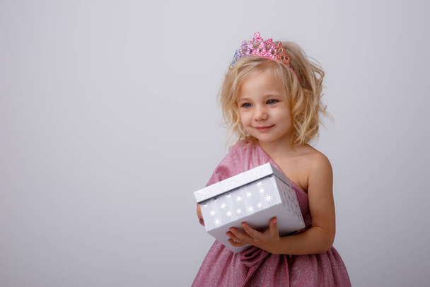 schöne kleine blonde Prinzessin mit einem Geschenk in ihren Händen  - Foto, Bild