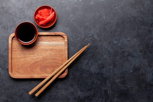 Holzteller und Essstäbchen für Sushi und Maki. Hintergrund der japanischen Speisekarte. Draufsicht flach lag mit Kopierraum - Foto, Bild