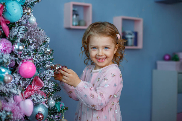 маленькая девочка с рождественскими украшениями дома - Фото, изображение