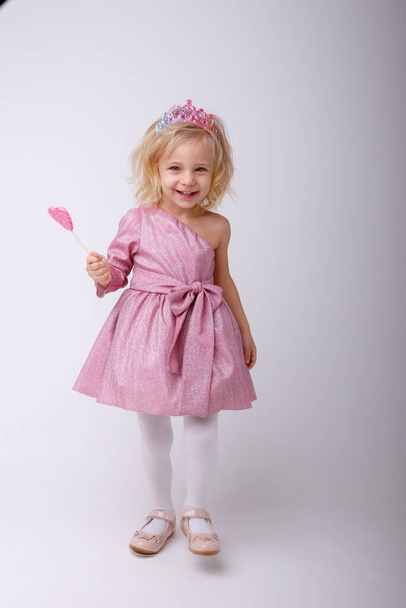 beautiful little blonde girl posing with a heart shaped Lollipop  - Valokuva, kuva