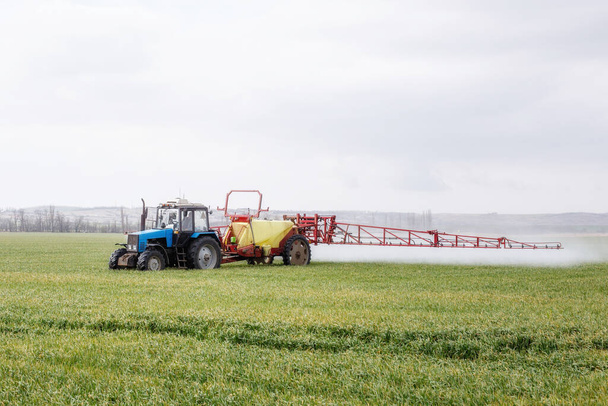 tractor rocía el campo con fertilizantes - Foto, imagen