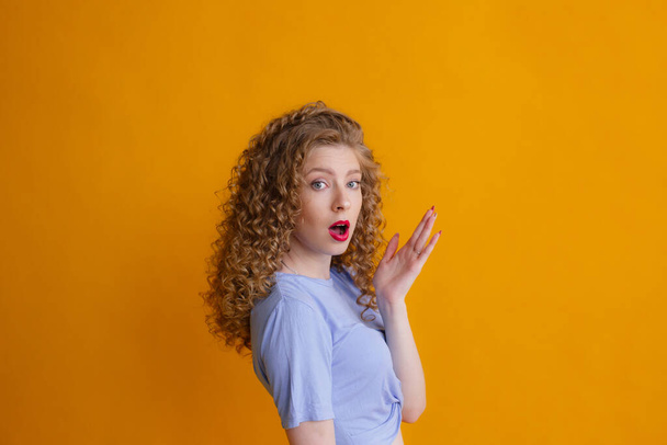 Portret van gember vrouw poseren tegen oranje achtergrond - Foto, afbeelding