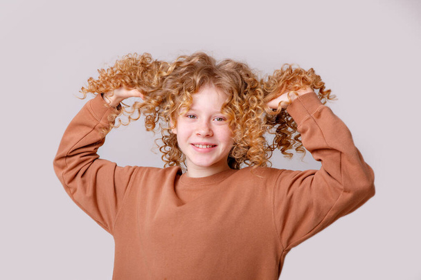 portrait of curly teenage girl posing in studio - Photo, Image