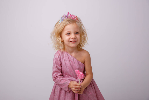 mooi klein blond meisje met een hartvormige Lollipop  - Foto, afbeelding