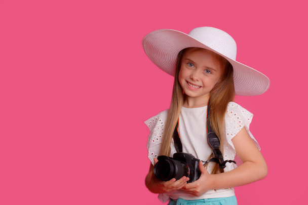 Portret dziewczyny podróżującej z aparatem fotograficznym na różowym tle - Zdjęcie, obraz