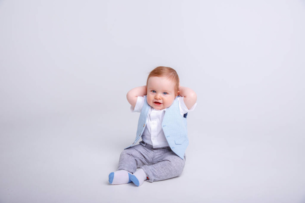 suloinen vauva poika poseeraa studiossa vastaan harmaa - Valokuva, kuva