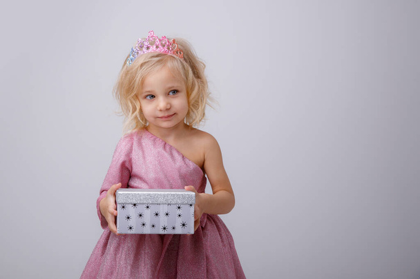 hermosa niña rubia princesa con un regalo en sus manos  - Foto, Imagen