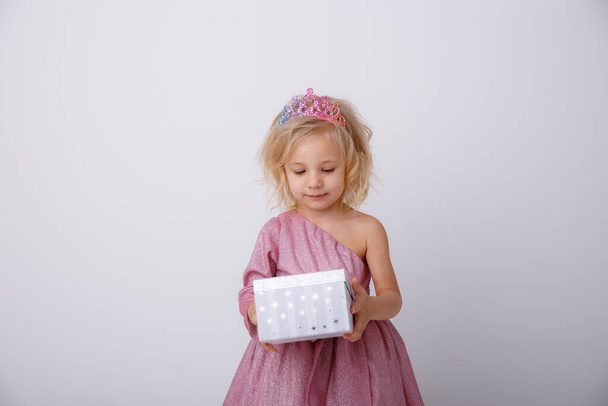beautiful little girl blonde Princess with a gift in her hands  - Fotoğraf, Görsel