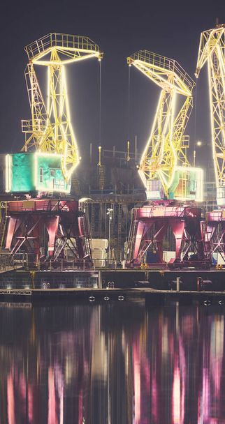 Osvětlené přístavní jeřáby na ostrově Lasztownia ve Štětíně v mlhavé noci, Polsko. - Fotografie, Obrázek