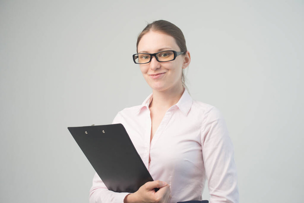 Happy beautiful woman in glasses business with a clipboard - Фото, изображение