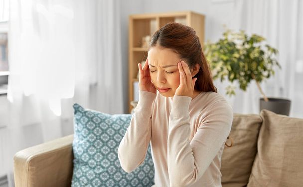 sick asian woman having headache at home - 写真・画像