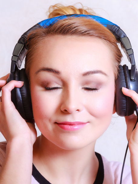 Femme moderne avec écouteurs écoutant de la musique - Photo, image