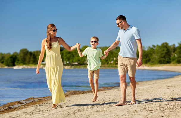 happy family walking along summer beach - 写真・画像