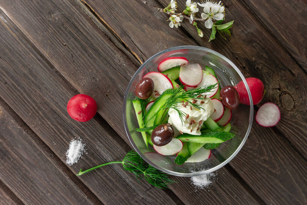 Draufsicht auf frischen Rettich und Gurkensalat auf Holzgrund - Foto, Bild
