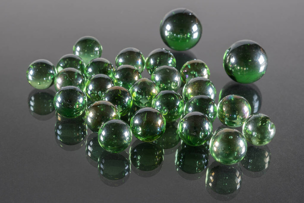 Kleine Emerald Green Glass Balls met reflectie en zwarte achtergrond. - Foto, afbeelding