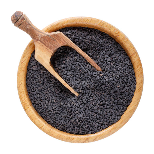 Black sesame seeds in wooden bowl isolated on white background. Top view. - Photo, Image