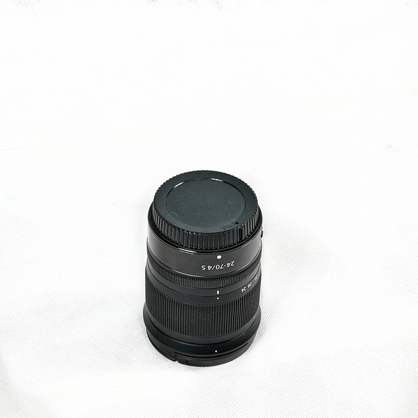 об'єктив чорної камери, що пришивається на білому тлі
 - Фото, зображення