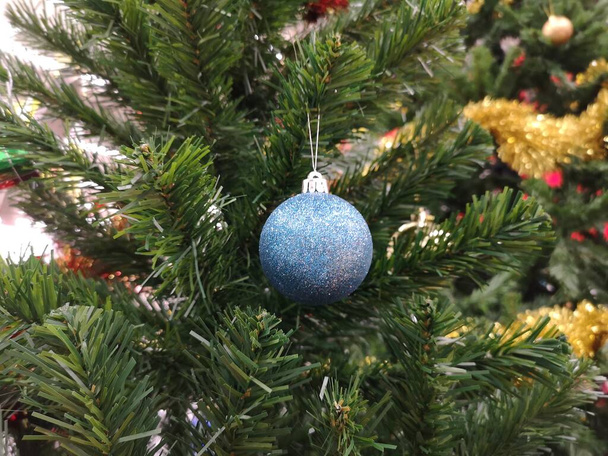 Koristeltu joulukuusi vihreä puu koristeet on sininen pallo, kulta lehdet hämärtynyt tausta - Valokuva, kuva