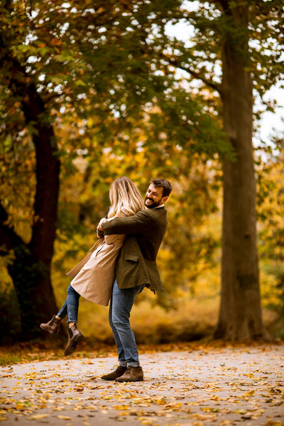 Handsome young couple having fun in the autumn park - Foto, Imagen