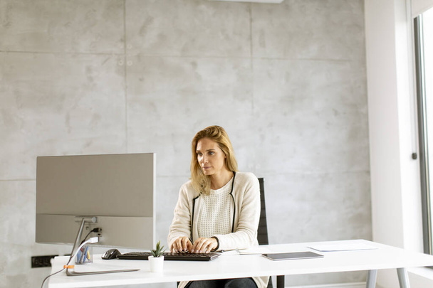 Bbeautiful businesswoman working on laptop in the bright modern office - Zdjęcie, obraz