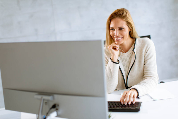 Bbeautiful businesswoman working on laptop in the bright modern office - Фото, зображення