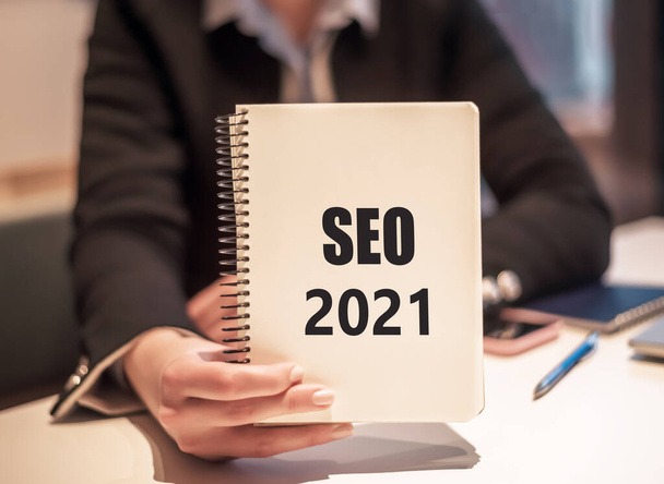 Seo 2021 concept - text on a Notepad in a business woman hand - Foto, Imagen