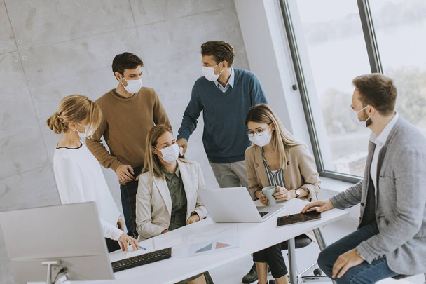 Group of business people have a meeting and working in the office and wear masks as protection from corona virus - Фото, зображення