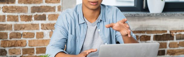 partial view of african american man gesturing near laptop, banner - Фото, изображение