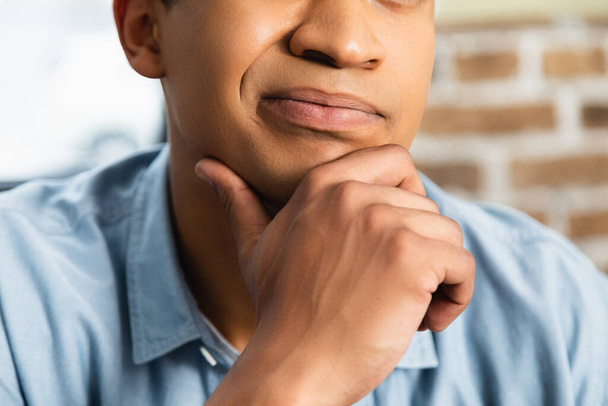 обрезанный вид задумчивого африканского американца касающегося подбородка  - Фото, изображение