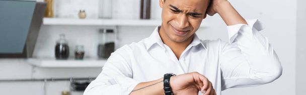 zestresowany Afroamerykanin patrzy na zegarek, sztandar - Zdjęcie, obraz